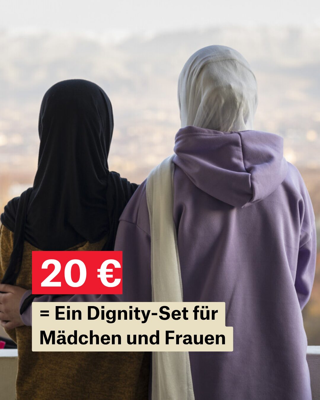 Zwei Mädchen mit Kopftüchern stehen draußen auf einem Balkon mit dem Rücken zur Kamera. Dabei schauen sie in die Ferne. Darunter die Aufschrift 20 Euro = Ein Dignity-Set für Mädchen und Frauen.