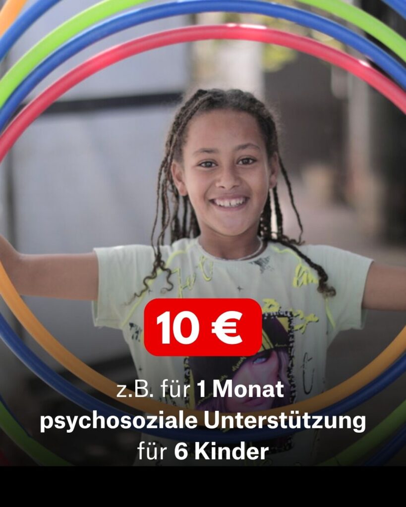 Ein lächelndes Mädchen hält mehrere bunte Hoolahoop-Reifen. Sie hat braune geflochtene Haare und ein hellgrünes Shirt. Die Beschriftung ist: 10€ z.B für 1 Monat psychosoziale Unterstützung für sechs Kinder.